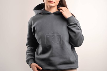 Woman in Stylish Hooded Sweatshirt. Fashionable Casual Wear. Hoodie design print mock-up. Beautiful Brunette girl.