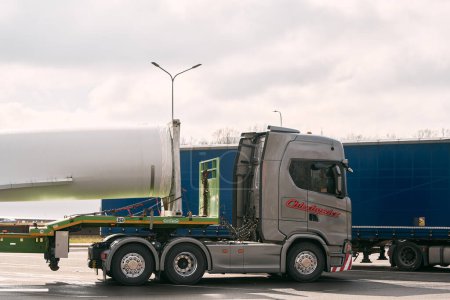 Téléchargez les photos : 08.04.2023 Pologne, Europe. Un gros semi-camion transportant une section d'éolienne à l'arrière de sa remorque. Convoi Traduction exceptionnelle : "Convoi exceptionnel". Charge surdimensionnée. - en image libre de droit