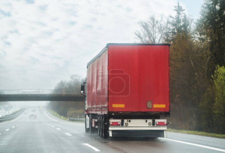 Freight delivery. Transport export industry. Container with loaded goods on background. Trucks on road. Trucker on highway. Lorry doing logistics work. Big cargo Truck.