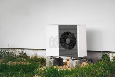 Foto de Compresor de aire acondicionado instalado al aire libre. Bombas de calor de aire al lado de una casa. - Imagen libre de derechos