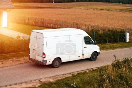 White delivery van. Modern delivery small shipment cargo courier van moving on a road. Delivery truck shipping parcels.