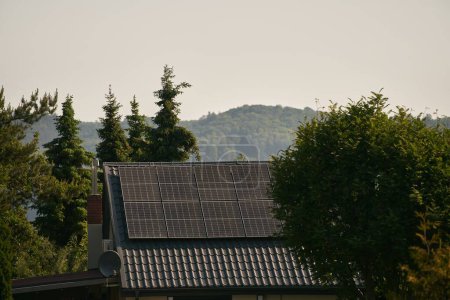 Téléchargez les photos : Panneaux solaires et énergies renouvelables sur le toit de la maison. Concept de ménage durable futur. - en image libre de droit