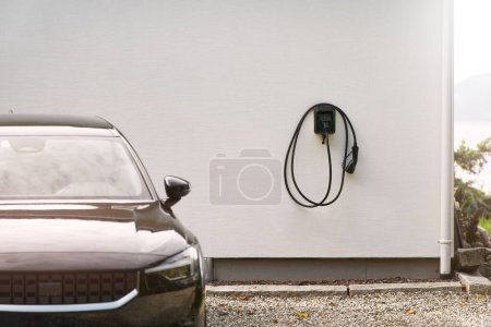 Foto de Estación cargadora de vehículos eléctricos en la pared. Energía EV concepto de coche. Batería de carga de vehículo híbrido futurista - Imagen libre de derechos