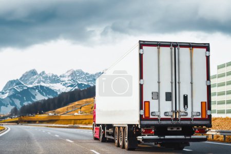Foto de Camión de carga en la carretera de montaña. Camión de reparto en la autopista Europa. Concepto de entrega global. - Imagen libre de derechos