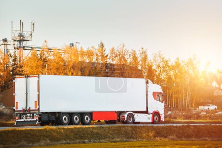 Téléchargez les photos : A truck transports cargo containers transported on land with semi trailers. Highway shipping and post delivery. Global commerce and industry that uses sustainable efficient logistics systems. - en image libre de droit