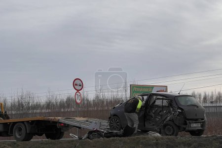 Photo for 02.02.2024 Poland, Europe. Toyota Yaris T-Bone Car Accident. Side crashed modern family car. Tow truck with a broken car on a road. Tow truck loading a hatchback on the highway. Car accident site. - Royalty Free Image