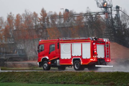 Foto de Un vehículo con una sirena conduce a un incendio. Es un camión de bomberos con bomberos y equipo de bomberos. - Imagen libre de derechos