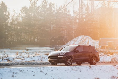 Performance de luxe rencontre le terrain d'hiver. SUV allemand noir Embrasse la route enneigée.