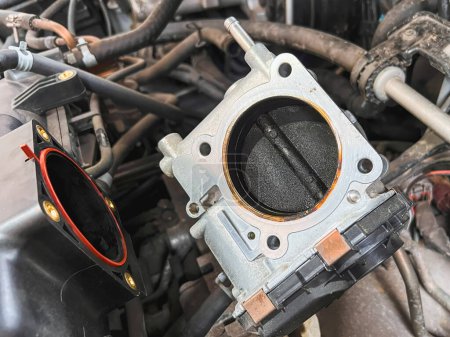 Kohlenstoffablagerungen beschädigen eine Drosselklappe eines Automotors. Das Ventilblatt ist verschmutzt und verkohlt, was die Motorleistung und den Wirkungsgrad senkt. Der Lufteinlass wird reduziert