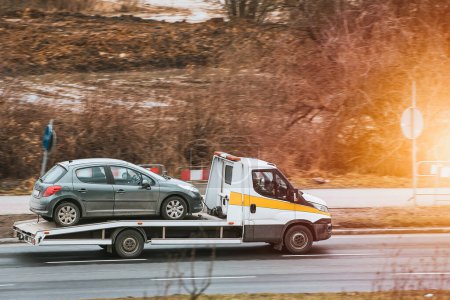 Photo for Flatbed Truck Transports Damaged Car Safely - Royalty Free Image