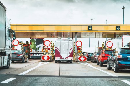 Photo for Traffic jam at highway toll plaza. Vehicles line up at a toll booth on a cloudy day, showcasing daily transportation costs - Royalty Free Image