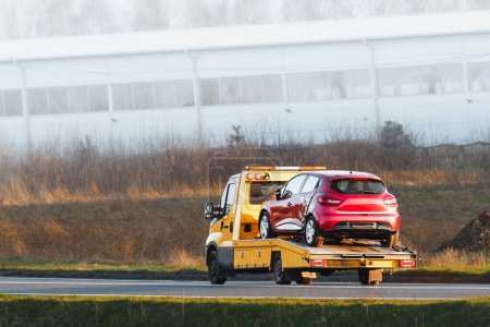 Photo for Flatbed Tow Truck in Action. Roadside Recovery 24 at 7 car service. - Royalty Free Image