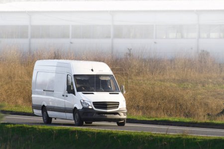 Commercial delivery van transports goods, symbolizing the relentless pace of modern commerce.