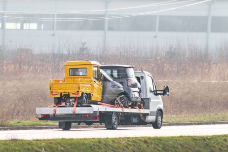 Assistance routière. Camion remorqueur transportant une voiture cassée sur une autoroute. dépanneuse à plat avec une voiture sur la route. Service de voiture concept de transport.