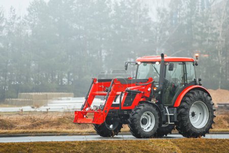 Tractor traveling on asphalt road to farming destination