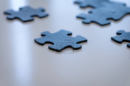 Photo for Dark blue jigsaw puzzle pieces on white backround ready to be placed. Negative space for copy at bottom of image. - Royalty Free Image