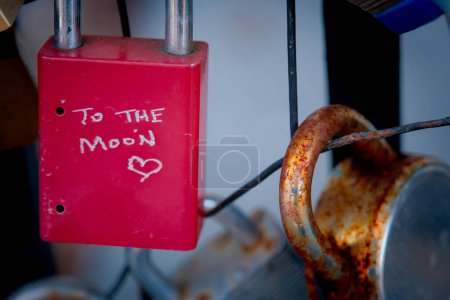 Photo for Red padlock that has been hand carved joins other on fence display. - Royalty Free Image