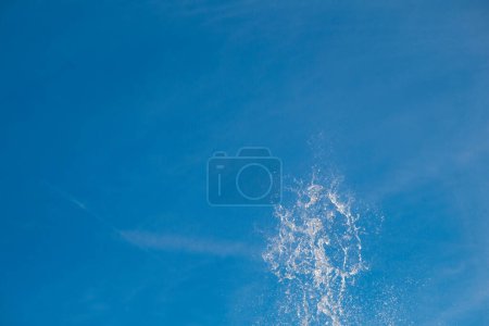 Téléchargez les photos : Water jet plashing and sparkling in bright sunny blue shy. - en image libre de droit