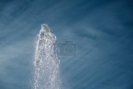 Téléchargez les photos : Intense jet of sparkling water in lighltly clouded afternoon sky. - en image libre de droit