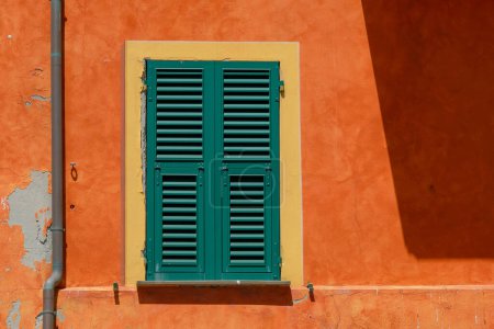 Photo for Sturdy green shutters and flaking orange wall in Camogli, Italy - Royalty Free Image