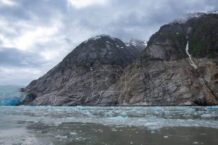 Téléchargez les photos : Falaises rocheuses avec nuages bas et glace du glacier Dawes - en image libre de droit