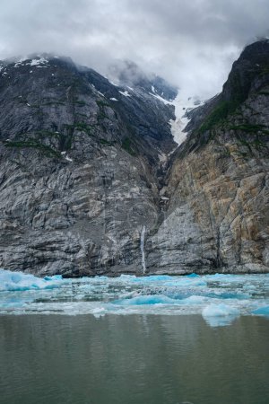 Téléchargez les photos : Falaises rocheuses avec nuages bas et glace du glacier Dawes - en image libre de droit