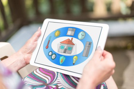 Photo for Smart home concept shown on a tablet held by a woman - Royalty Free Image