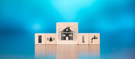 Téléchargez les photos : Blocs en bois avec symbole de concept de maison intelligente sur fond bleu - en image libre de droit