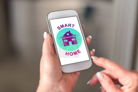 Téléchargez les photos : Concept de maison intelligente sur un smartphone tenu par une main - en image libre de droit