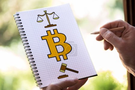 Téléchargez les photos : Dessin à la main Bitcoin concept de réglementation sur un bloc-notes - en image libre de droit