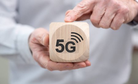 Hand holding a wooden cube with symbol of 5g concept