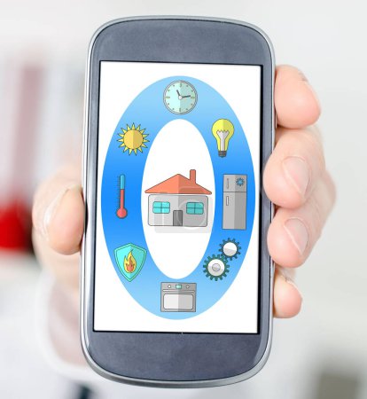 Téléchargez les photos : Main tenant un smartphone avec concept de maison intelligente - en image libre de droit
