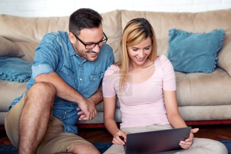 Young couple enjoying in shopping from home. Poster 626309084