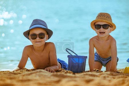 Foto de Niños pequeños jugando con juguetes de playa durante las vacaciones tropicales. - Imagen libre de derechos