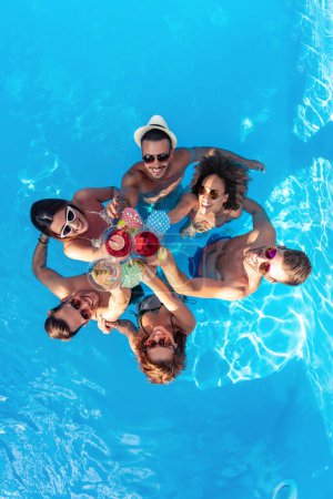 Foto de Summer holidays and vacation,group of friends toast with a cocktails in the pool. - Imagen libre de derechos
