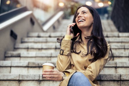 Téléchargez les photos : Femme d'affaires utilisant un téléphone intelligent et boire du café pour aller avant d'aller au travail tôt le matin. - en image libre de droit