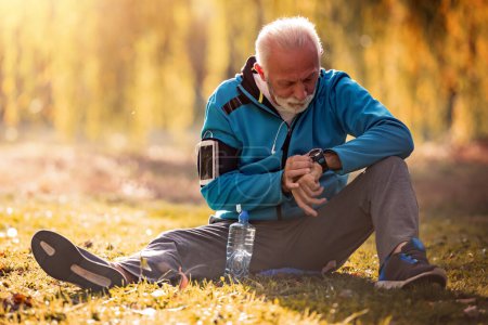Photo for Portrait of happy senior man in sportswear stretching in the park. - Royalty Free Image