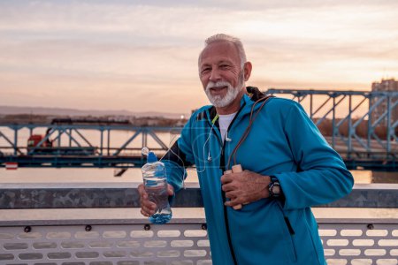 Photo for Senior man resting after workout outdoors and drink water.Fitness,sport,people and healthy lifestyle. - Royalty Free Image