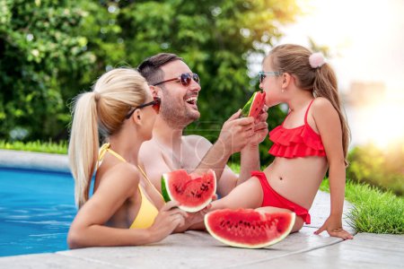 Téléchargez les photos : Jeune famille appréciant sur la piscine.Personnes, amour et concept de vacances. - en image libre de droit