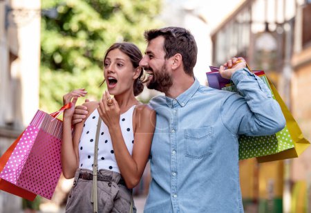 Foto de Retrato de pareja feliz con bolsas de compras después de comprar en la ciudad. - Imagen libre de derechos