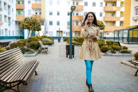 Téléchargez les photos : Femme dans le parc de la ville, boire du café et utiliser un téléphone mobile. - en image libre de droit