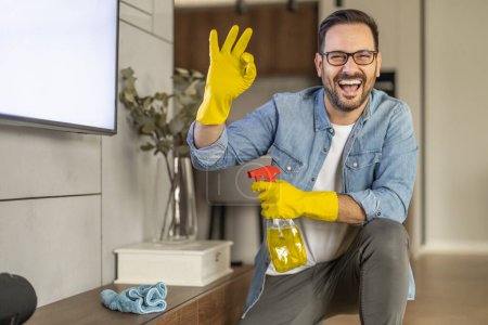 Téléchargez les photos : Bel homme nettoyage cuisine à la maison.Entretien ménager et concept de nettoyage. - en image libre de droit