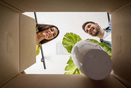 Téléchargez les photos : Jeune couple déménageant dans une nouvelle maison.Couple s'amuse avec des boîtes en carton dans une nouvelle maison lors du déménagement day.Couple autour des boîtes en carton. - en image libre de droit