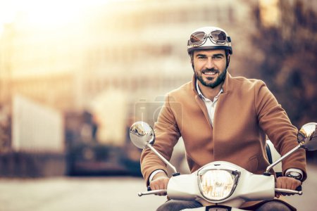 Téléchargez les photos : Portrait d'homme d'affaires souriant à l'extérieur, il conduit scooter. - en image libre de droit