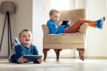 Téléchargez les photos : Enfants heureux jouant à des jeux vidéo à la maison. - en image libre de droit