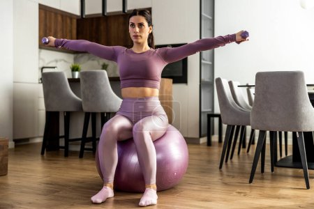 Foto de Mujer de fitness haciendo ejercicio de mancuerna en casa. - Imagen libre de derechos
