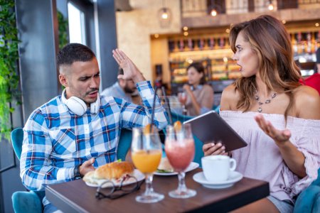 Photo for Couple in restaurant drink juice ,eat sandwiches and have some problems in relationships. - Royalty Free Image