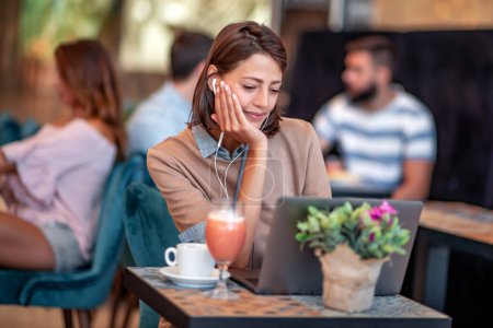 Téléchargez les photos : Jeune femme travaillant sur son ordinateur portable dans un café. Concept d'entreprise et style de vie. - en image libre de droit