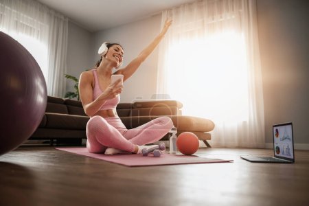 Photo for Fitness woman doing exercise in living room. Athletic girl working out home. - Royalty Free Image