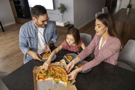 Photo for Mom, dad and daughter are eating together in kitchen. Happy family concept. - Royalty Free Image